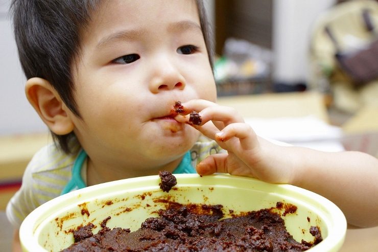 味噌を使った料理を頬張る子ども